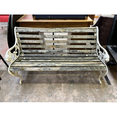 31 - A Victorian style white painted cast iron and wooden slatted garden bench - approx. 73cm high x 120c... 