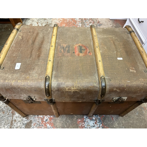 74 - An early 20th century brown fibreboard and wooden banded travel trunk