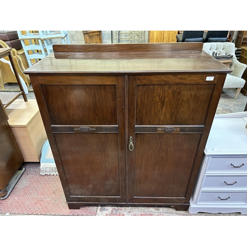 77 - An Edwardian carved mahogany two door cabinet
