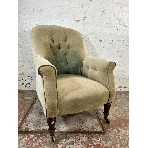 82 - A Victorian fabric upholstered button back armchair with rosewood supports and brass castors - appro... 