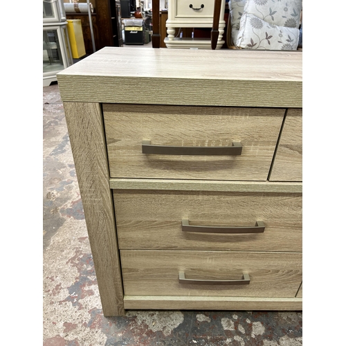 93 - A modern oak effect chest of drawers - approx. 78cm high x 125cm wide x 44cm deep