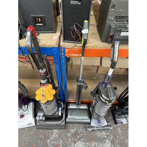 828 - Three bagless upright vacuum cleaners, one Vax Mach Air Reach, one Gtech Air Ram and one Dyson DC33