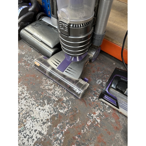 828 - Three bagless upright vacuum cleaners, one Vax Mach Air Reach, one Gtech Air Ram and one Dyson DC33