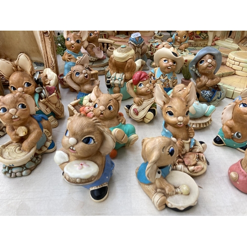 378 - A collection of Pendelfin rabbit figurines and display stands to include Old Schoolhouse, Fruit Shop... 