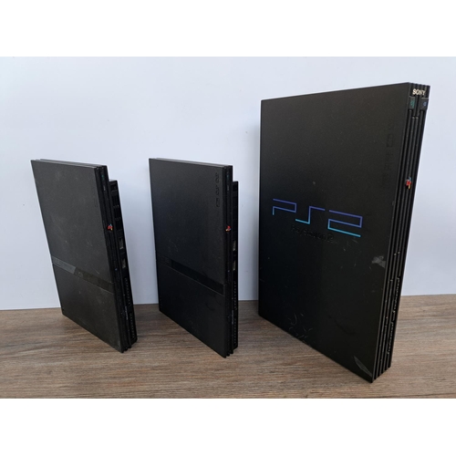 733 - Three Sony PlayStation 2 consoles, two slim and one original with cables, four controllers, one offi... 