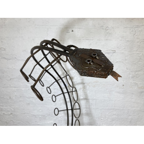 425 - A large bespoke made wrought iron snake shaped ten section floor standing bottle rack - approx. 91cm... 