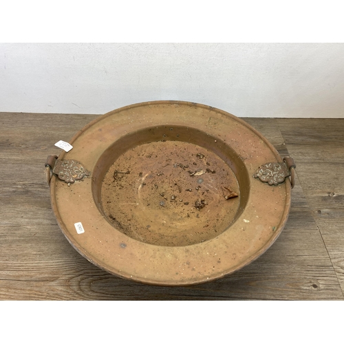 427A - A late 19th/early 20th century copper pedestal two handled bowl on brass lion paw feet - approx. 50c... 