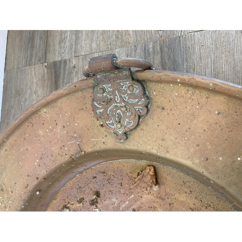 427A - A late 19th/early 20th century copper pedestal two handled bowl on brass lion paw feet - approx. 50c... 