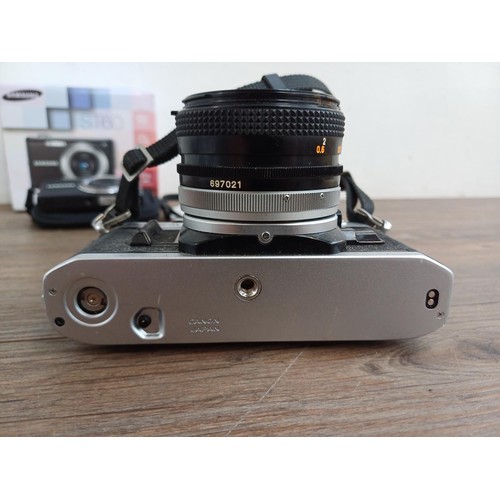 646 - Two cameras, one Canon AE-1 35mm SLR fitted with FD 50mm 1:1.8 S.C. lens and one boxed and cased Sam... 