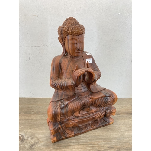 542 - A carved hardwood seated meditating Buddha figurine - approx. 52cm high x 32cm wide