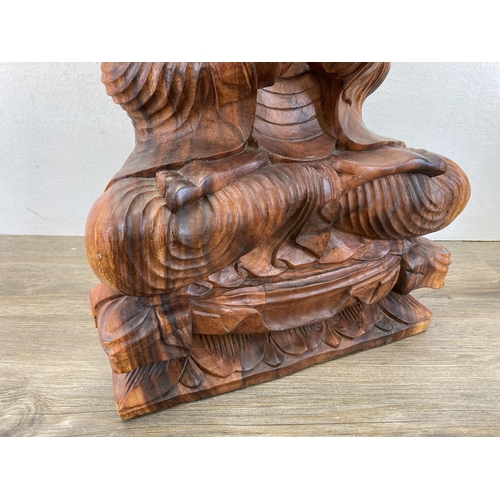 542 - A carved hardwood seated meditating Buddha figurine - approx. 52cm high x 32cm wide