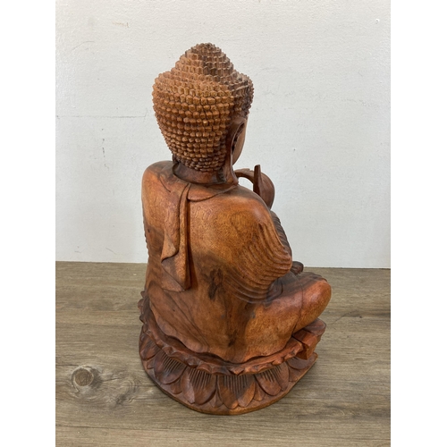 542 - A carved hardwood seated meditating Buddha figurine - approx. 52cm high x 32cm wide