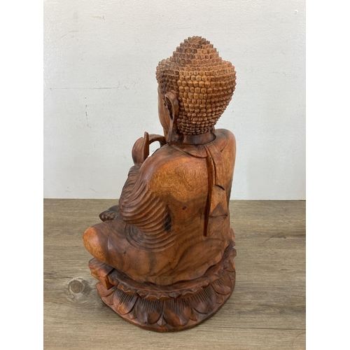 542 - A carved hardwood seated meditating Buddha figurine - approx. 52cm high x 32cm wide