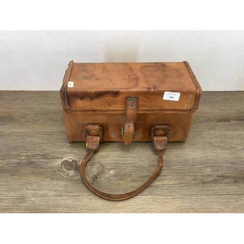 559 - A vintage brown leather bag containing a collection of vintage first aid accessories