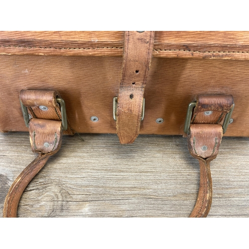 559 - A vintage brown leather bag containing a collection of vintage first aid accessories