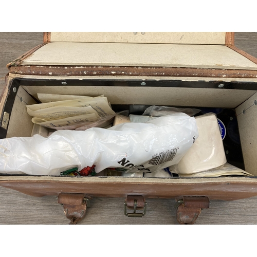 559 - A vintage brown leather bag containing a collection of vintage first aid accessories