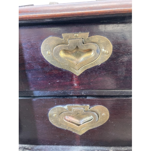 562 - A vintage Chinese hardwood miniature three door cabinet with brass details and original lock and key... 