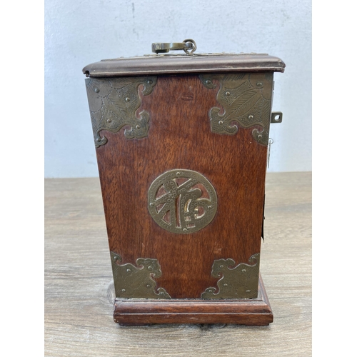 562 - A vintage Chinese hardwood miniature three door cabinet with brass details and original lock and key... 