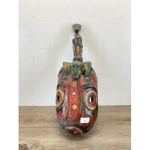 575 - A tribal carved wooden and hand painted wall mask - approx. 54cm long x 20cm wide