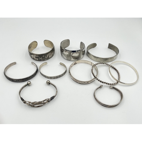 2421 - A collection of white metal cuff bracelets