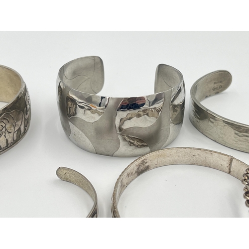 2421 - A collection of white metal cuff bracelets