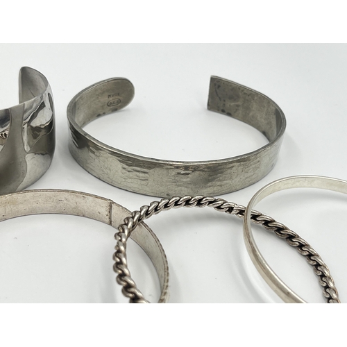 2421 - A collection of white metal cuff bracelets