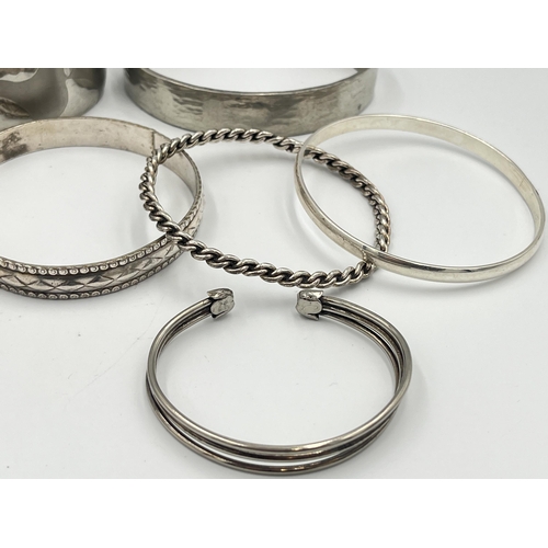 2421 - A collection of white metal cuff bracelets