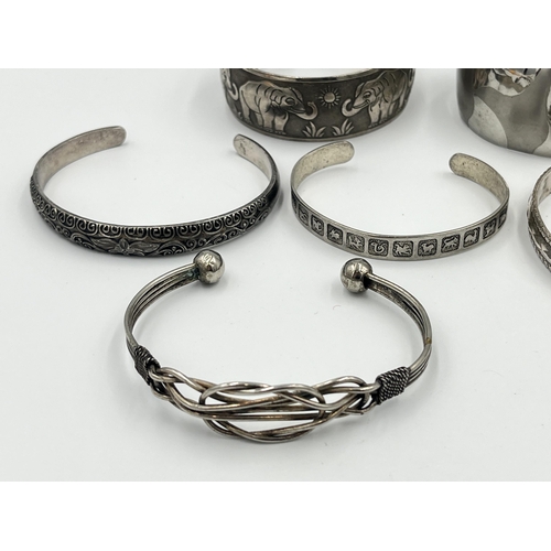 2421 - A collection of white metal cuff bracelets