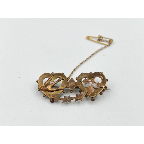 2483 - A Victorian hallmarked Birmingham 9ct gold double heart brooch with swallow and foliate design and b... 