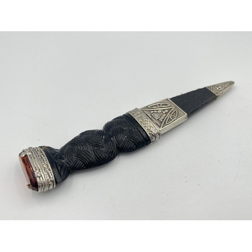 2319 - A J. Nowill & Sons Ltd. Skean-DHU dagger with sheath, carved handle and amber glass and white metal ... 