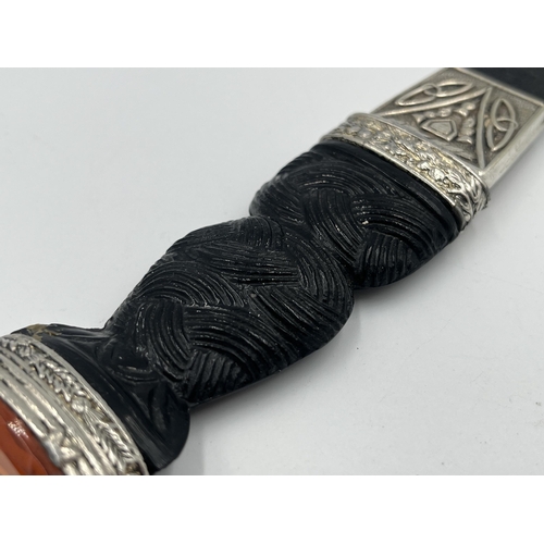 2319 - A J. Nowill & Sons Ltd. Skean-DHU dagger with sheath, carved handle and amber glass and white metal ... 