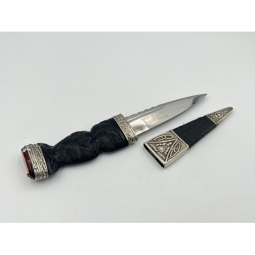 2319 - A J. Nowill & Sons Ltd. Skean-DHU dagger with sheath, carved handle and amber glass and white metal ... 