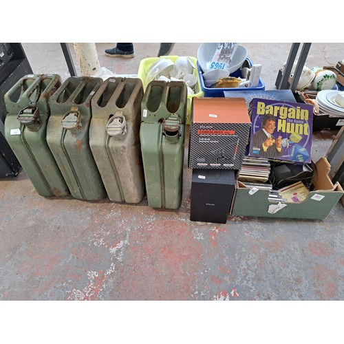 1055 - A collection of items to include four green metal jerry cans, JVC stereo system, CDs etc.