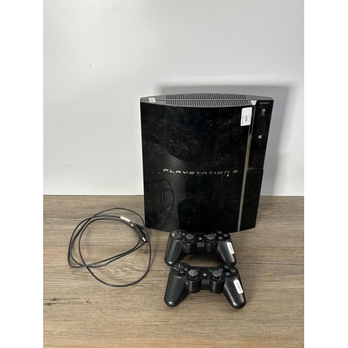 734 - A Sony PlayStation 3 CECH-A01 console with two Sixaxis controllers