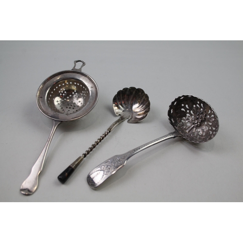 2249 - Three silver items to include sterling sugar sifter, sterling tea strainer etc. - approx. gross weig... 