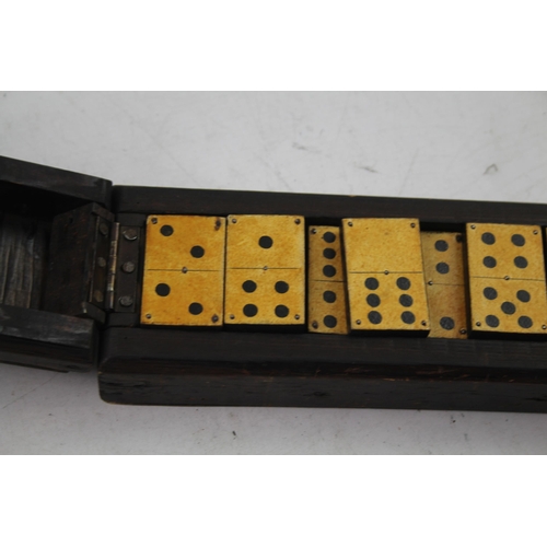 563 - A late 19th/early 20th cased dominoes set and cribbage board