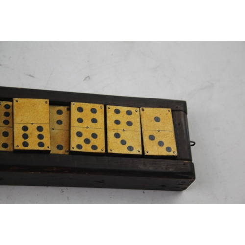 563 - A late 19th/early 20th cased dominoes set and cribbage board