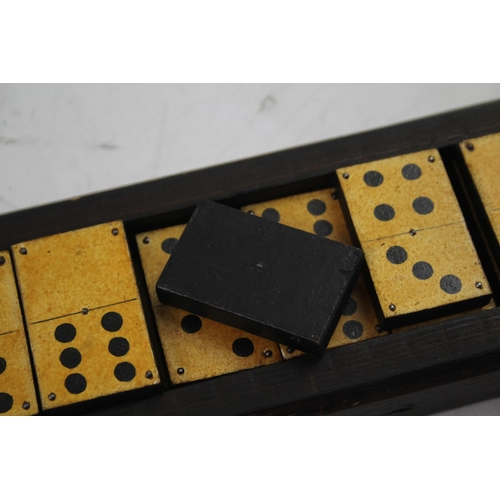 563 - A late 19th/early 20th cased dominoes set and cribbage board