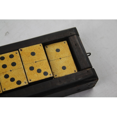 563 - A late 19th/early 20th cased dominoes set and cribbage board