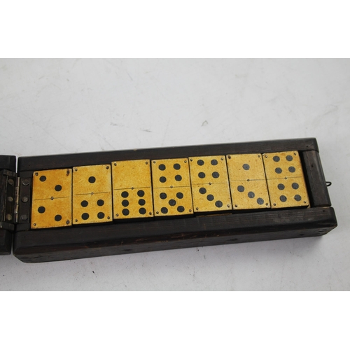 563 - A late 19th/early 20th cased dominoes set and cribbage board