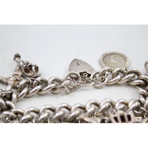 2301 - A silver charm bracelet with assorted charms - approx. gross weight 111g