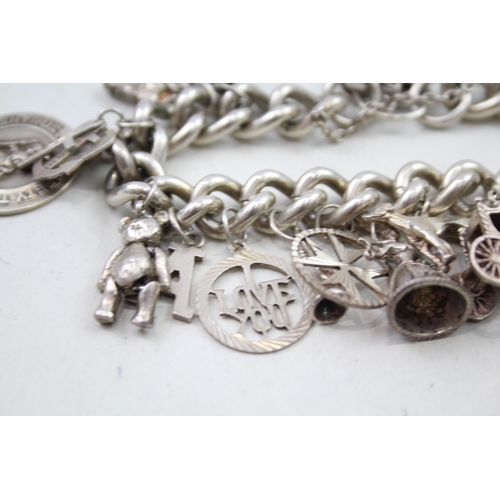 2301 - A silver charm bracelet with assorted charms - approx. gross weight 111g