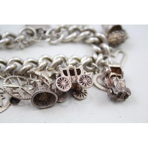 2301 - A silver charm bracelet with assorted charms - approx. gross weight 111g