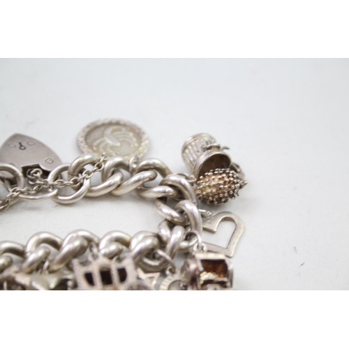 2301 - A silver charm bracelet with assorted charms - approx. gross weight 111g