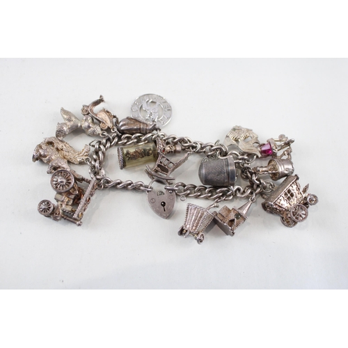 2305A - A silver charm bracelet with assorted charms - approx. gross weight 92g