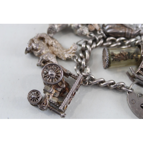 2305A - A silver charm bracelet with assorted charms - approx. gross weight 92g