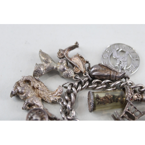 2305A - A silver charm bracelet with assorted charms - approx. gross weight 92g