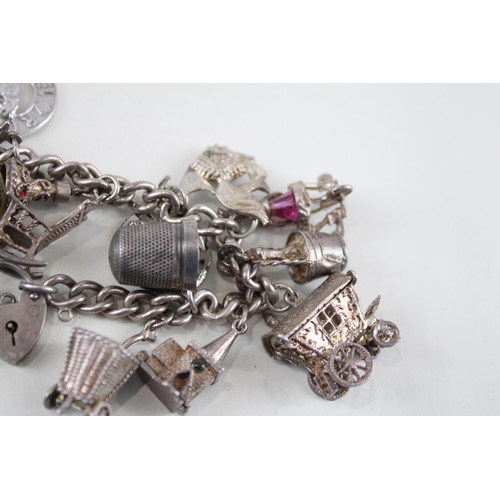 2305A - A silver charm bracelet with assorted charms - approx. gross weight 92g