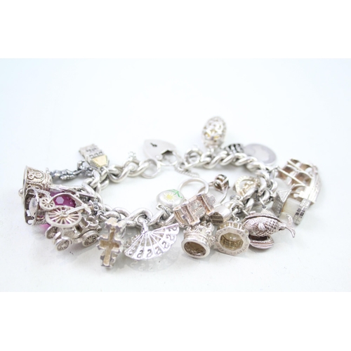 2310 - A silver charm bracelet with assorted charms - approx. gross weight 109g