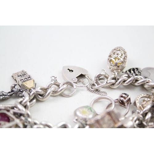 2310 - A silver charm bracelet with assorted charms - approx. gross weight 109g